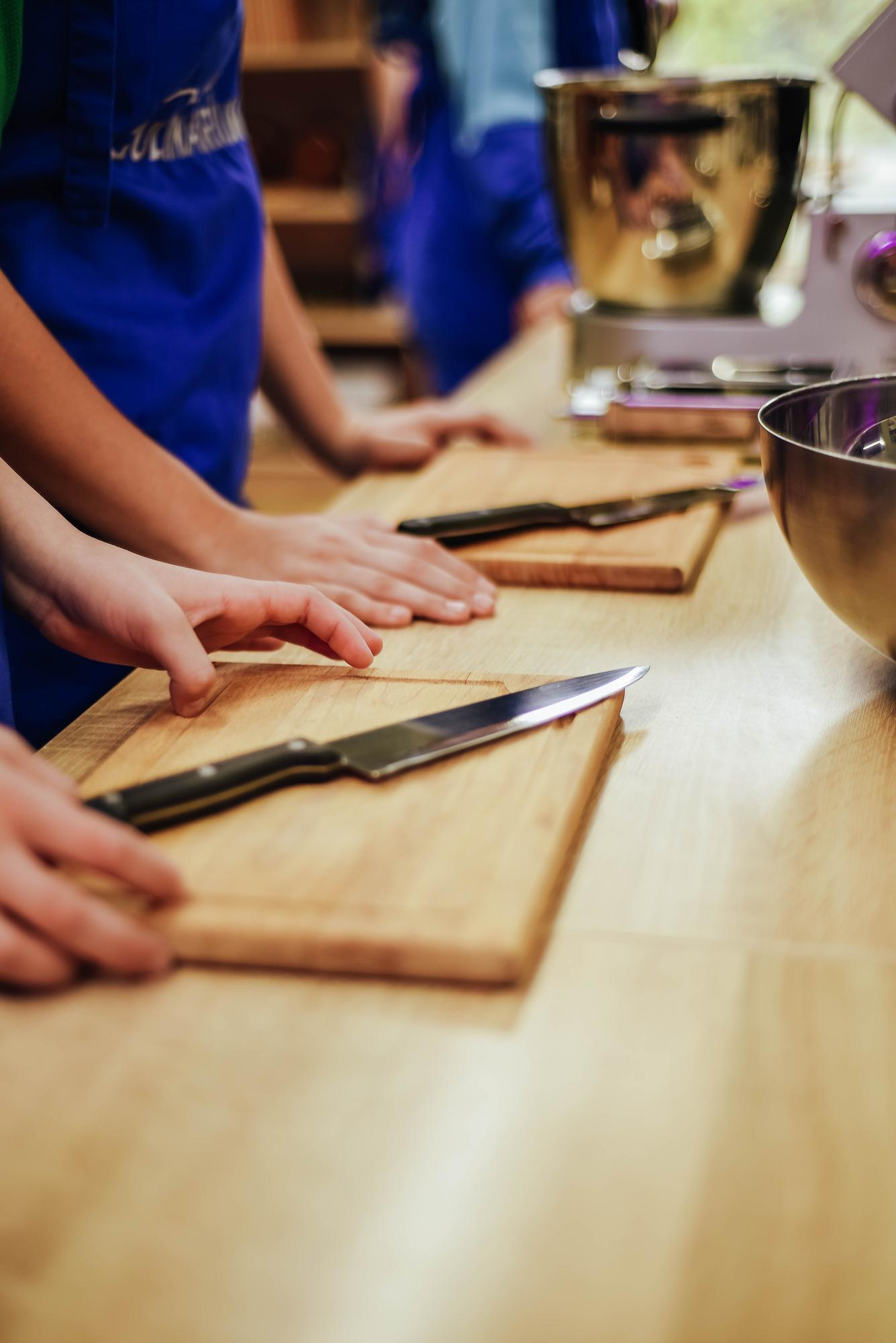 Chef instructing two students at bench